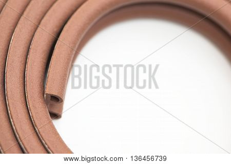 Closeup of roll of brown multipurpose sticking bumper over white background