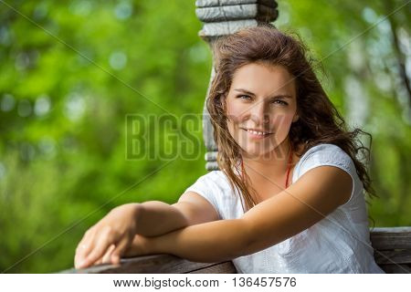 Portrait of young smilin woman in the summer park