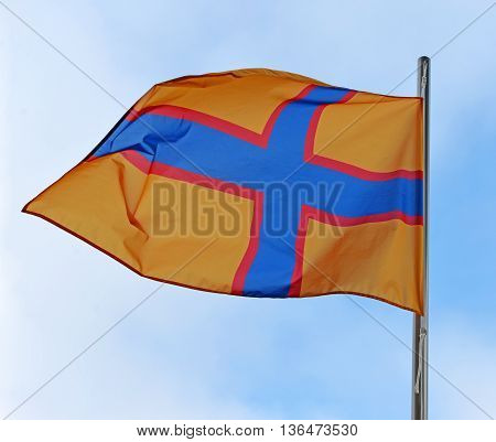 Ingermanland flag waving in the wind against a blue sky with clouds. Ingermanland (Inkeri Ingeri) ethnocultural and historical area in the northwest of Russia.
