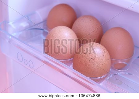 Pick chicken egg from the refrigerator, eggs on shelf of refrigerator