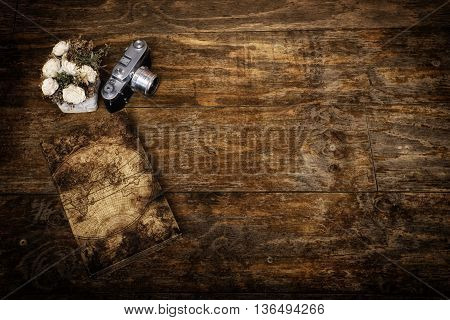 Sweet memories collage with travel diary, flowers and old photo camera on rustic vintage surface