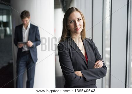 Group of business people, a woman in jacket and man in a suit, winter city landscape outside the window on the background
