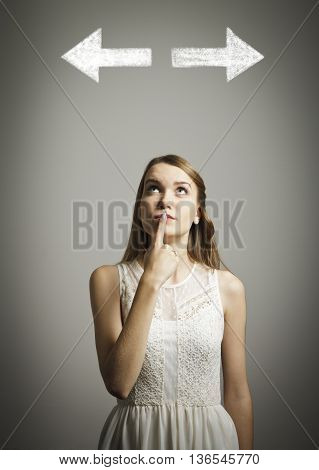 Girl in white has to decide between two directions. Girl in white full of doubts and hesitation.