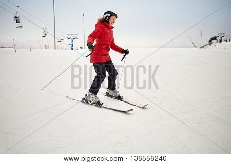 Woman skis on slope in winter day at sports complex.
