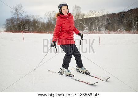 Woman skis on slope in winter day at sports complex.