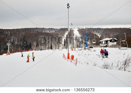 People skiing and snowboarding at winter ski slope.