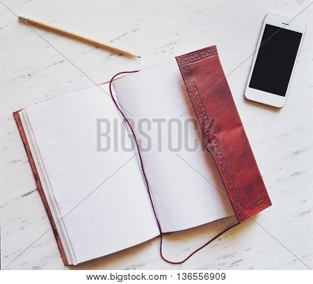 Top View Of Notepad, Smartphone And Pencil On Marble Background