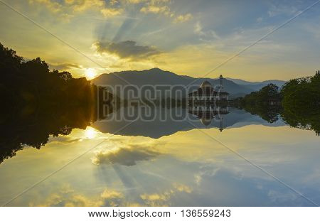 Majestic view of Darul Quran Mosque during sunset with mirror reflection in the lake. Soft focus due to long exposure. Virant colours.