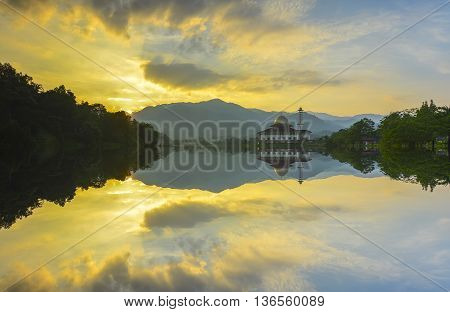 Majestic view of Darul Quran Mosque during sunset with mirror reflection in the lake. Soft focus due to long exposure. Virant colours.