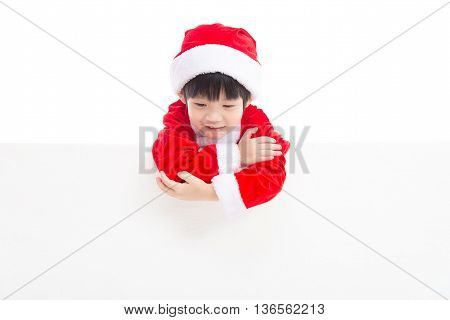 Little asian boy in Santa Claus uniform with an empty banner isolated on white