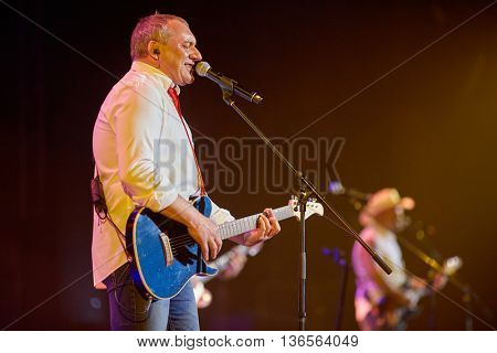 MOSCOW, RUSSIA - APR 24, 2015: Nikolay Fomenko with guitar singing in concert on stage of Crocus city hall at Secret band show. Rock and roll band Secret founded in 1982 in Leningrad.