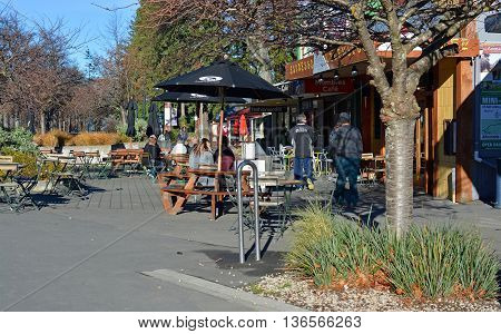 Hanmer Springs New Zealand - June 25 2016: People at a popular outdoor cafe in the main street of the Tourist Town of Hanmer Springs North Canterbury in winter.