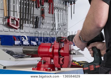 Workshop scene. Close up of hands with drill.