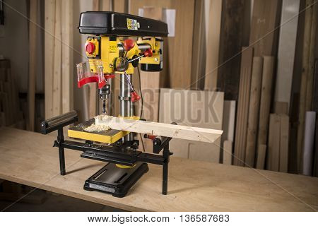 Vertical drilling machine on table with tools
