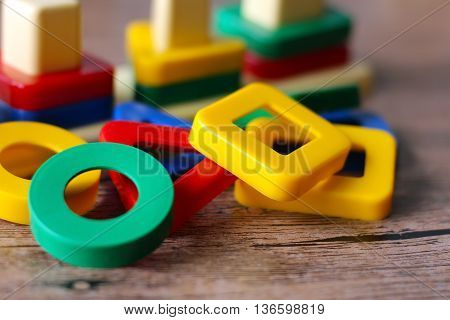 colored geometric forms on wooden table, toys.