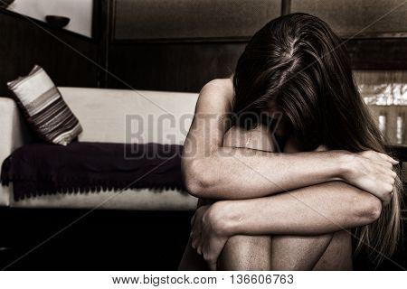 Sad woman sitting alone in a empty room next to the bed. domestic violence.