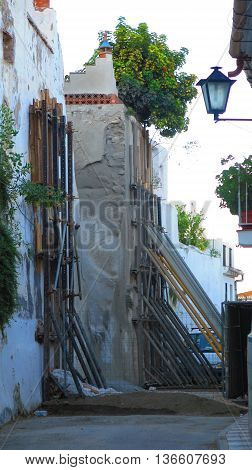 propping up retaining wall in narrow street in Alora Andalusia