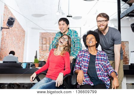 business people fun playing office chair race man push woman colleagues casual group competitive team
