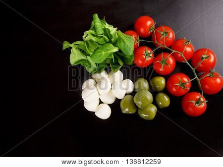 Ingredients for Caprese salad on black background