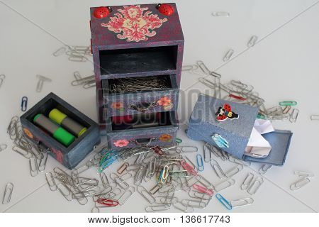 A handmade mini chest of three drawers decoupaged with floral vintage paper handmade objects decorated using different techniques of decoupage