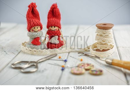 sewing tools like thimble, bobbin lace, pins, scissors, etcetera on wooden background