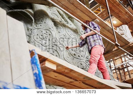 RUSSIA, MOSCOW - MAY 28, 2015: Female employee works on fragment of clay sculpture to St. Vladimir in the workshop of sculptor Salavat Shcherbakov. Monument will be installed at Borovitskaya square.