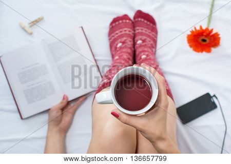 Woman Reading A Book And Having Cup Of Tea