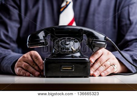 Telephone On Foreground With Hands Of An Office Worker