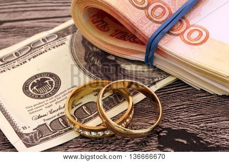 Two wedding rings and money. Dollars. Golden rings