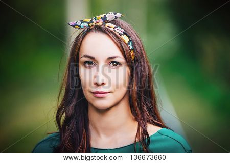 Portrait of a girl with a bow on his head gentle and young brunette the summer day