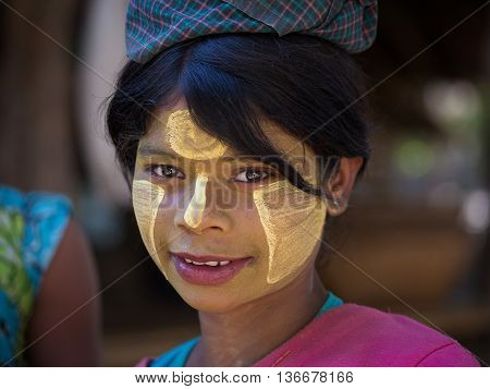 MRAUK-U MYANMAR - JANUARY 27 2016: Unidentified young Myanmar girl with thanaka on her smile face is happiness. Thanaka is a yellowish-white cosmetic paste made from ground bark.