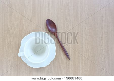 White coffice cup and wooden spoon in top view on wood background for design concept food.
