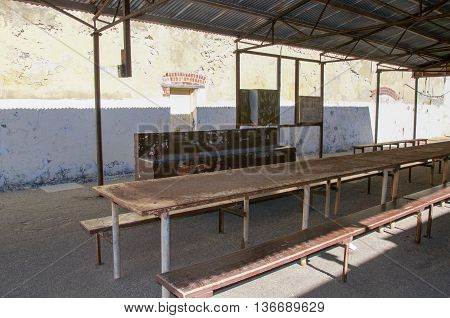 FREMANTLE,WA,AUSTRALIA-JUNE 1,2016: Outdoor yard with shelter, sink and long weathered table at the Fremantle Prison in Fremantle, Western Australia.