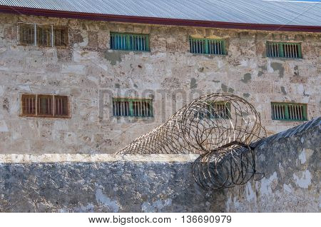 FREMANTLE,WA,AUSTRALIA-JUNE 1,2016:  Limestone exterior walls and razor wire security fencing at the Fremantle Prison in Fremantle, Western Australia.