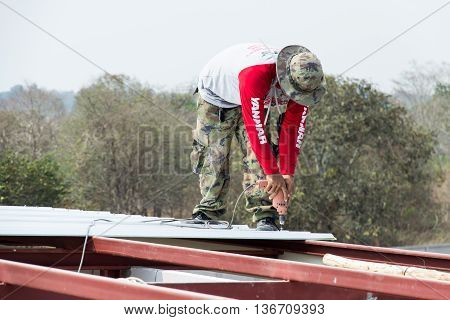 BURIRUM THAILAND - FEBRUARY 24 2016: Man working on roof Metal cheese in site nangrong BURIRUM THAILAND.