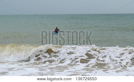 Waves and surfer in coastline town of  Seaton Devon