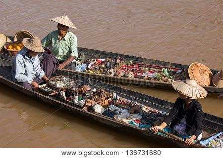 INLE LAKE MYANMAR - JANUARY 14 2016 : Unidentified Burmese people on small long wooden boat selling souvenirs trinkets and bijouterieat the floating market on Inle Lake Myanmar