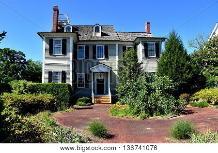 New Bern North Carolina - April 24 2016: Wooden gray clapboard 1835 Dixon House and garden courtyard at Tryon Palace