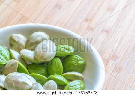 Parkia speciosa ( petai bitter bean twisted cluster bean stinker or stink bean) with white cup and spoon