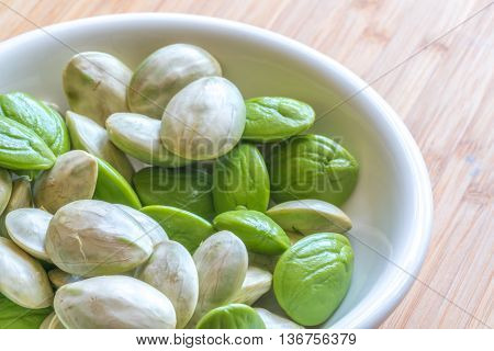 Parkia speciosa ( petai bitter bean twisted cluster bean stinker or stink bean) with white cup and spoon