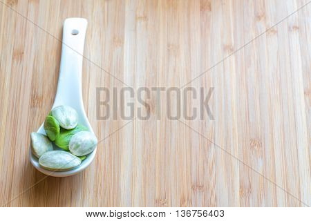 Parkia speciosa ( petai bitter bean twisted cluster bean stinker or stink bean) with white cup and spoon