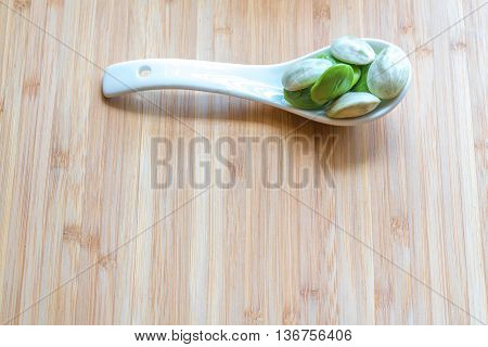 Parkia speciosa ( petai bitter bean twisted cluster bean stinker or stink bean) with white cup and spoon