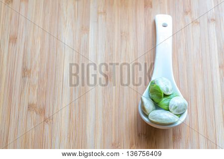 Parkia speciosa ( petai bitter bean twisted cluster bean stinker or stink bean) with white cup and spoon
