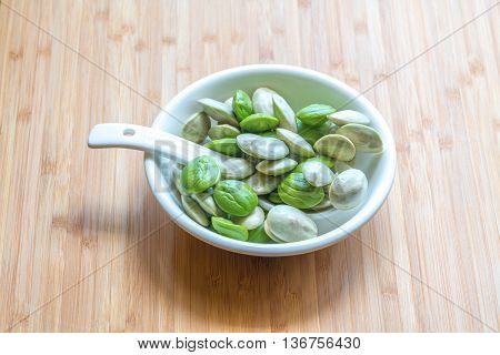 Parkia speciosa ( petai bitter bean twisted cluster bean stinker or stink bean) with white cup and spoon