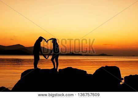 Silhouette of young couple in love at beachsunset background