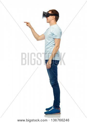 3d technology, virtual reality, entertainment, cyberspace and people concept - happy young man with virtual reality headset or 3d glasses playing game and touching something