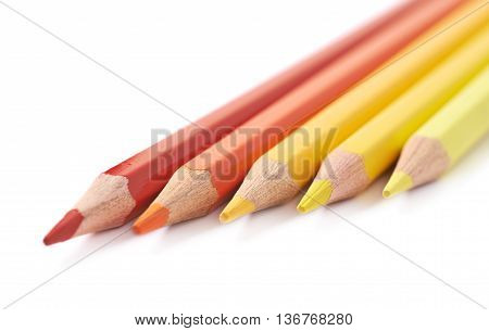 Line of five color pencils, composition isolated over the white background, close-up crop fragment composition