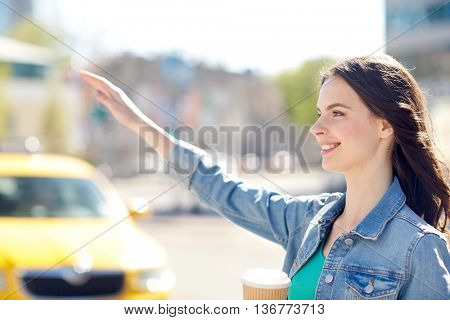 gesture, lifestyle, travel and people concept - happy young woman or teenage girl drinking coffee from paper cup on city street