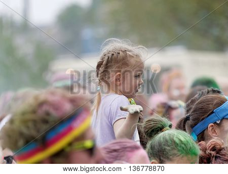 STOCKHOLM SWEDEN - MAY 22 2016: Young girl sitting on her fathers shoulders in the Color Run Event in Sweden May 22 2016