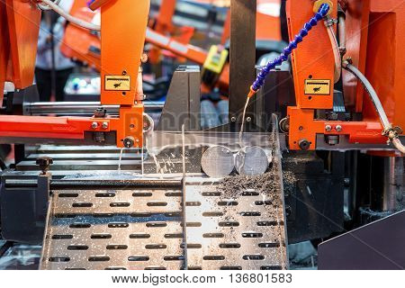 Steel band saw machine working in industry factory.